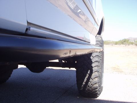 1993 Ford Bronco - A close-up side view of a 1993 Ford Bronco, highlighting its off-road tire and lower body panel.