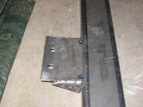 1995 Ford Bronco - A close-up view of a custom metal bracket, likely for vehicle modification, attached to a steel beam.