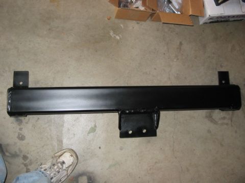 1995 Ford Bronco - A black metal bumper bracket is shown lying on a concrete floor with cardboard boxes in the background.