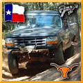 1993 Ford Bronco - A black Ford Bronco navigates a challenging off-road path.