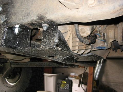 1995 Ford Bronco - Close-up view of the undercarriage, focusing on the transmission and custom suspension components.