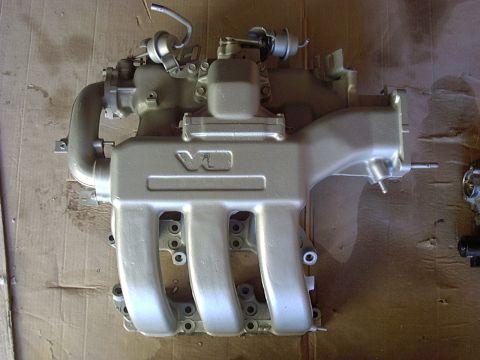 1995 Ford Probe - Intake manifold with V6 marking, likely from a car engine. Mounted on cardboard.