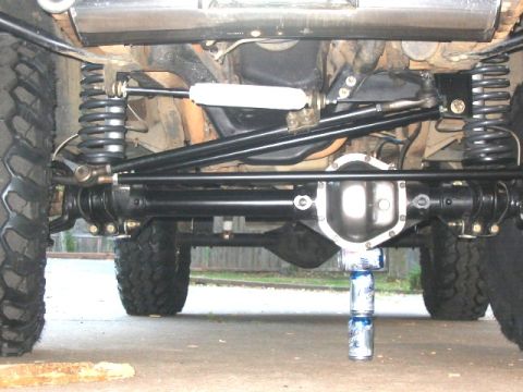 1995 Ford Bronco - The underside of a vehicle is shown, with a focus on the suspension and drivetrain components.