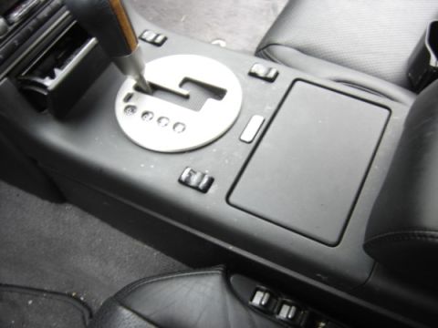 1999 Ford Taurus - Close-up of the automatic gear shifter and center console area within a vehicle's interior.