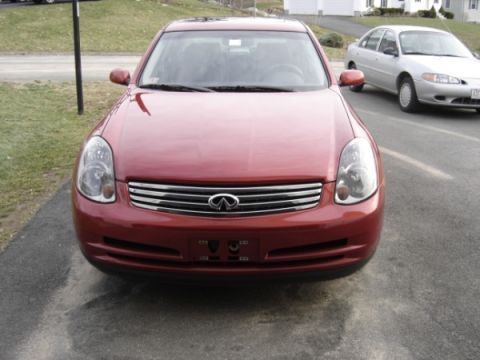 1999 Ford Taurus - A red Infiniti sedan is parked in front of a silver sedan on a paved surface.