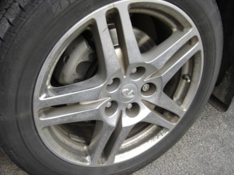 1999 Ford Taurus - A close-up view of a vehicle's wheel, revealing the brake system and a distinctive Infiniti emblem.
