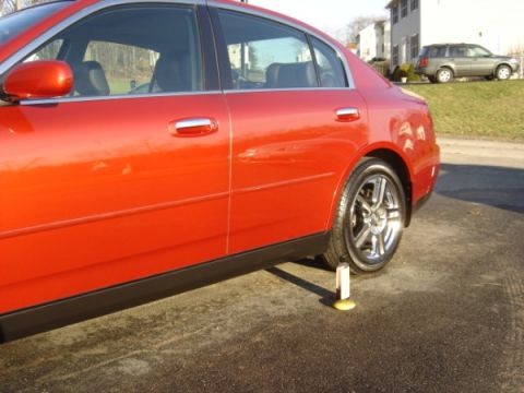 1999 Ford Taurus - A red sedan is shown from the side, with one wheel elevated by a chock.