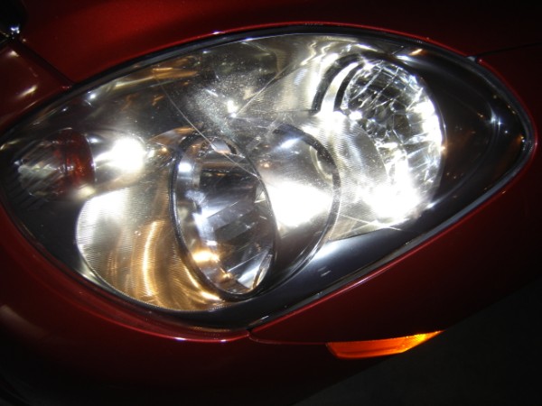 close-up of a car's headlight assembly, showing the clear lens and internal reflectors