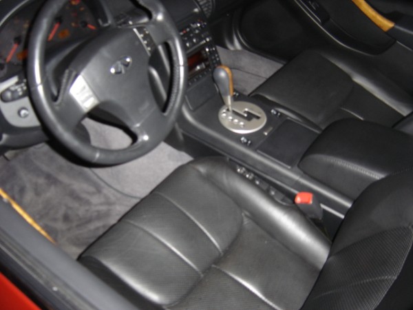 Car interior with black leather seats, steering wheel, and center console with automatic shifter