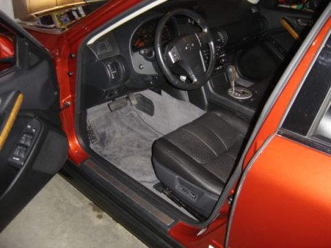 1999 Ford Taurus - The interior of an orange car is visible, black leather seats and a dashboard.