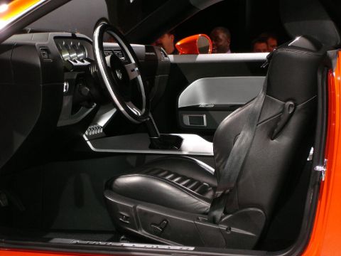 1986 Ford Bronco - The interior of a modern car is visible, a black leather seat and dashboard details.