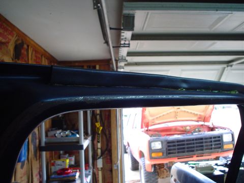 1984 Ford Bronco - View of interior trim with an orange SUV in the background, likely from the early 1980s.