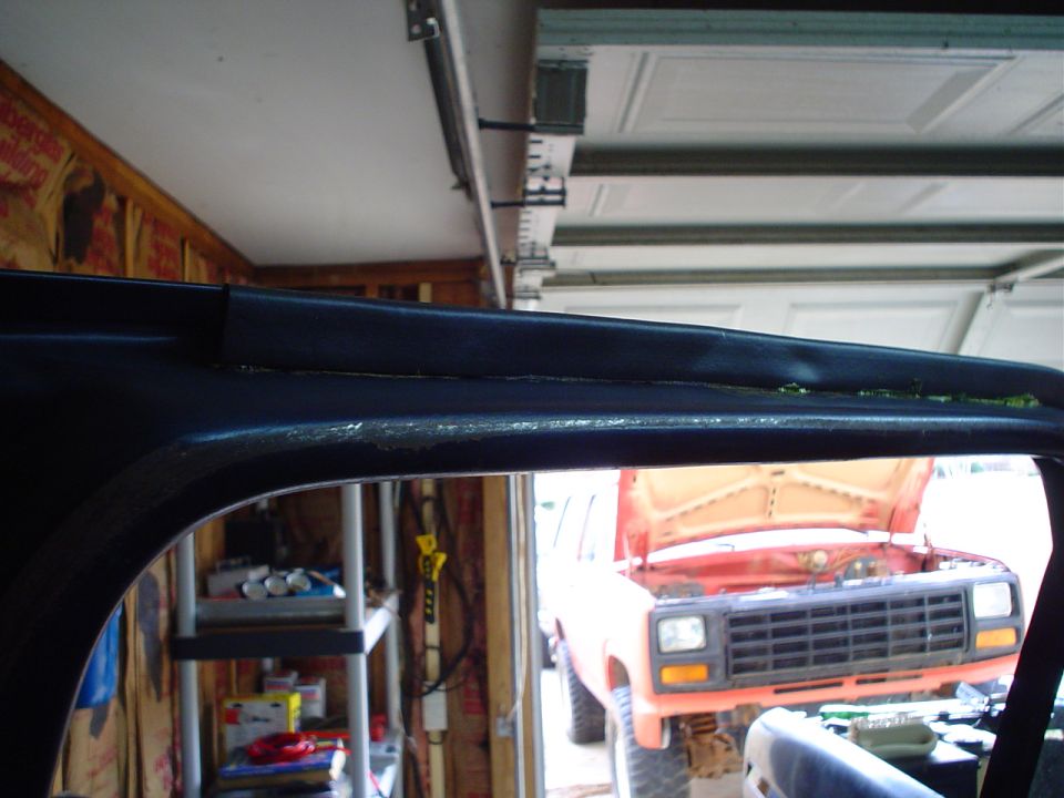 Interior trim detail with orange SUV visible through doorway