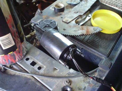 1984 Ford Bronco - Close-up of a vehicle's window motor assembly, showing wiring and mechanical components.