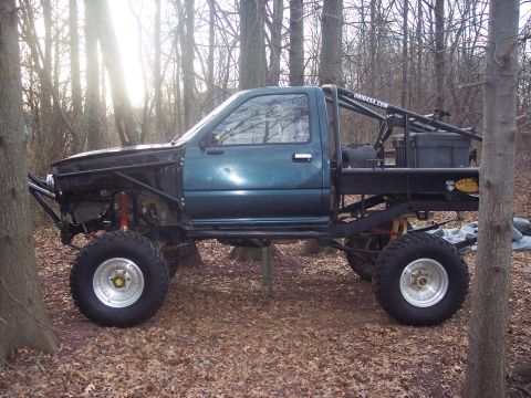 1995 Toyota Tacoma - This heavily modified pickup truck features oversized off-road tires, a custom roll cage, and a flatbed conversion.