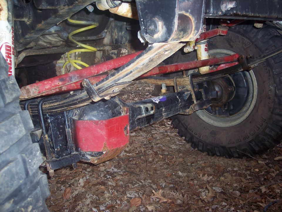 Rear axle and suspension of a truck with leaf springs and red shocks