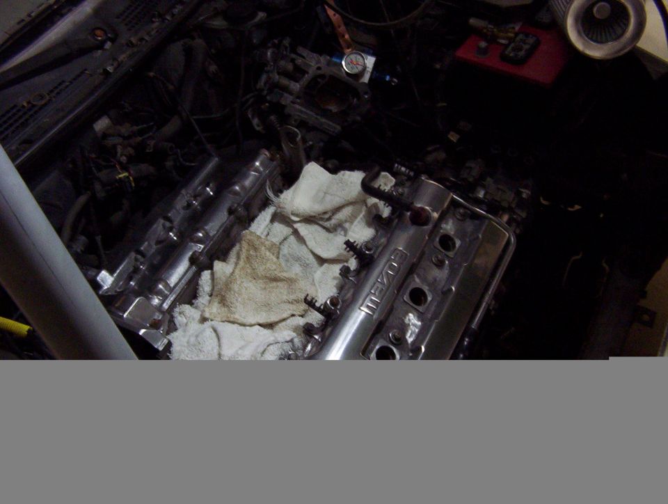 Mazda engine bay with chrome valve cover and rags