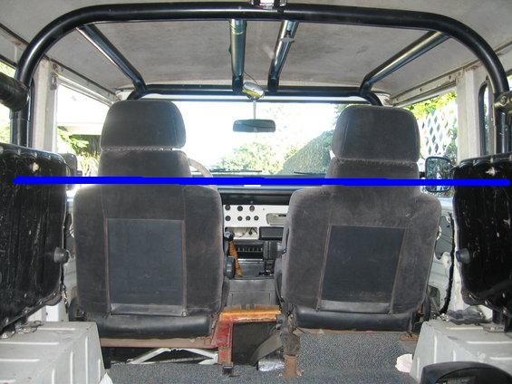 Interior of hardtop 4x4 from rear: black bucket seats, roll cage, white body tub