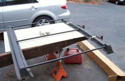 1979 Ford Bronco - Roof rack assembly is on jack stands next to a silver car and a red gas can.