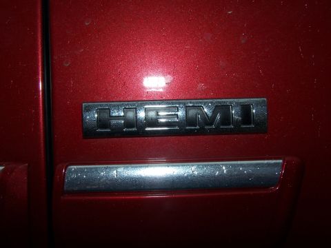 1979 Ford F-150 - Close-up of a HEMI badge on a red vehicle's door panel.