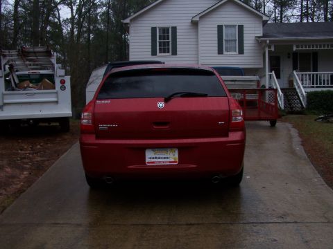 1979 Ford F-150 - A red Dodge Magnum wagon is parked in a driveway next to a utility truck and a small trailer.