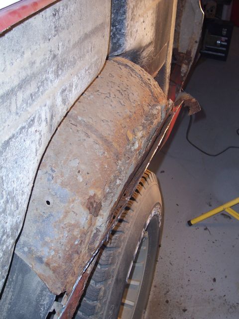 1978 Ford Bronco - The heavily rusted quarter panel and tire suggest significant wear and tear on the vehicle.