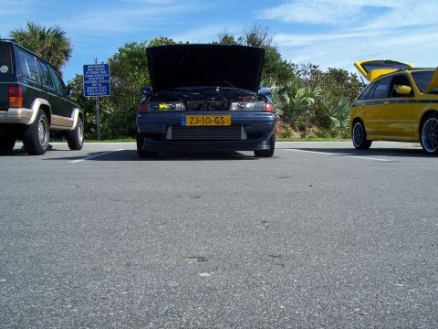1994 Ford Probe - A dark blue Mazda 626 is parked with its hood open, alongside other vehicles.