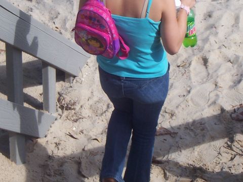 1994 Ford Probe - A person walks on a sandy path next to wooden stairs, holding a soda and wearing a backpack.