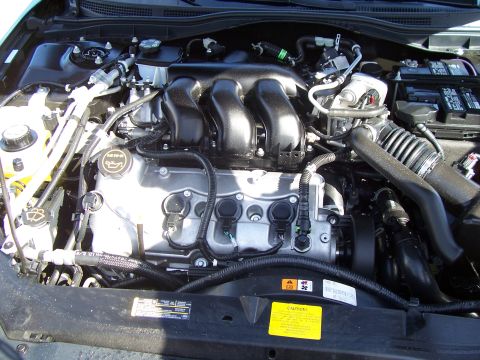 1994 Ford Probe - The engine bay of a vehicle, a V6 intake manifold and an oil cap with an oil can symbol.