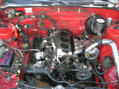 1992 Nissan 240SX - Engine bay with cylinder head removed, revealing internal engine components and a turbocharger.