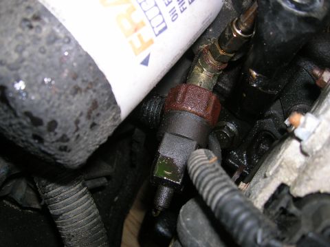 1992 Nissan 240SX - The oil filter and a sensor are visible on the engine block, with some oil residue present.