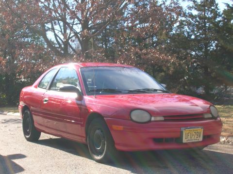 1992 Nissan 240SX - A red coupe is parked outdoors on a sunny day, showing its front three-quarter view.