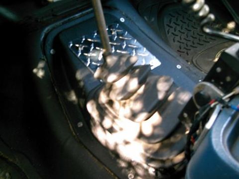 1986 Ford Bronco - Close-up view of the transfer case shifter boot and diamond plate trim, likely from an older 4x4 vehicle.