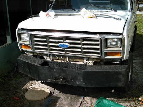 1986 Ford Bronco - The front of a white Ford Bronco is shown with a custom aftermarket bumper installed.