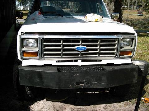1986 Ford Bronco - Front view of a white Ford truck, showing the grille and bumper.
