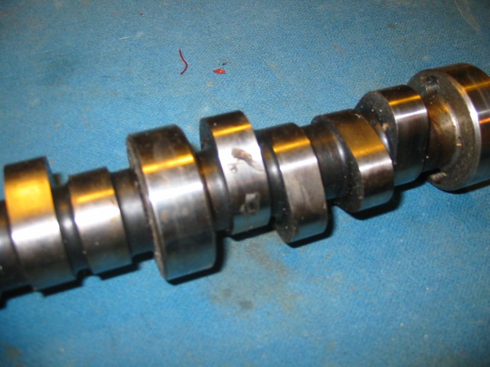 Camshaft with multiple lobes on a blue surface