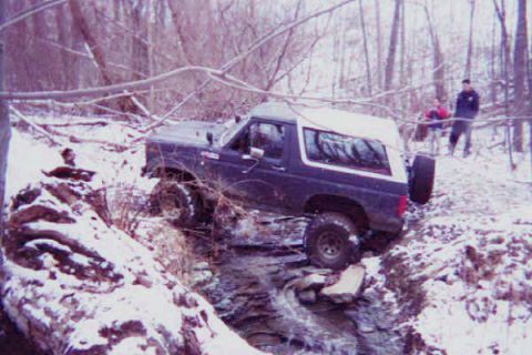 1986 Ford Bronco - This 1986 Ford Bronco navigates a challenging off-road course in a snowy, wooded environment.