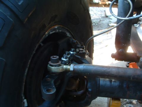 1994 Jeep YJ - Close-up view of the front wheel steering linkage on a 1994 Jeep YJ, showing the tie rod end and shock absorber.