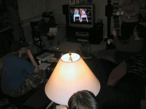 1985 Ford LTD Crown Victoria - People gather in a living room to watch television, illuminated by a table lamp.