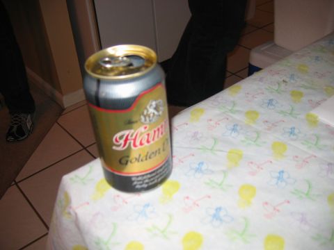 1985 Ford LTD Crown Victoria - A beer can sits on a table covered with a patterned cloth, with people in the background.