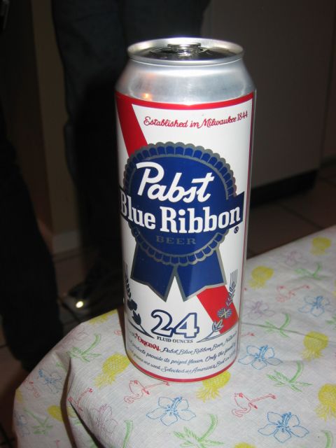 1985 Ford LTD Crown Victoria - A Pabst Blue Ribbon beer can is shown on a tablecloth with a tropical flower and flamingo pattern.