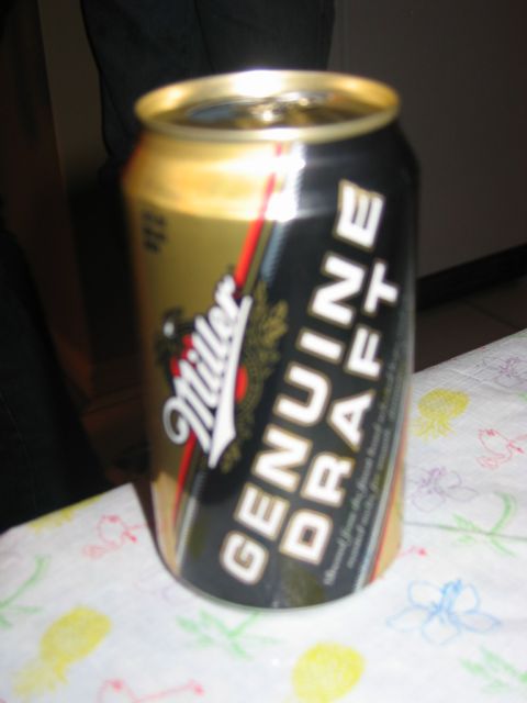 1985 Ford LTD Crown Victoria - A can of Miller Genuine Draft beer is shown on a tablecloth with colorful floral patterns.