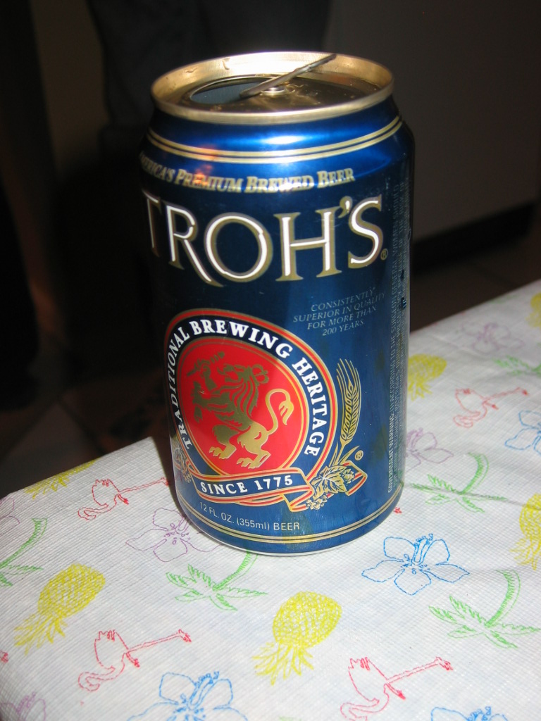 Troh's beer can on a tablecloth with pineapples and flamingos