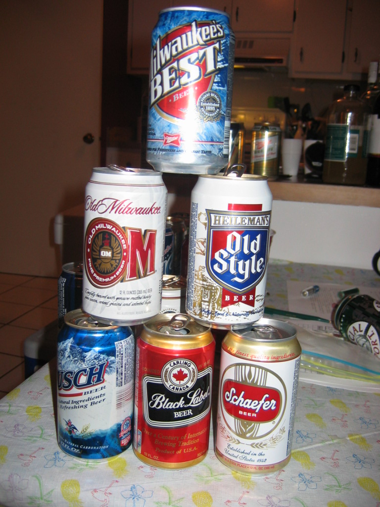 Pyramid of beer cans including Milwaukee's Best, Old Milwaukee, Heileman's Old Style, Busch, Carling Black Label, and Schaefer