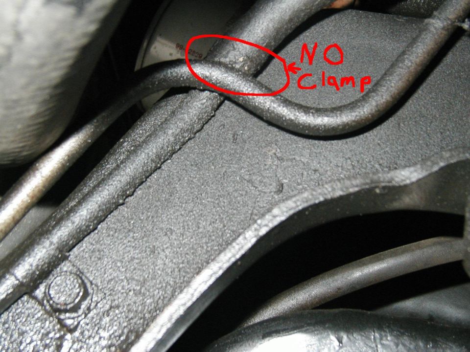 Annotated close-up of an unclamped metal line on a black bracket, marked 'NO Clamp' in red