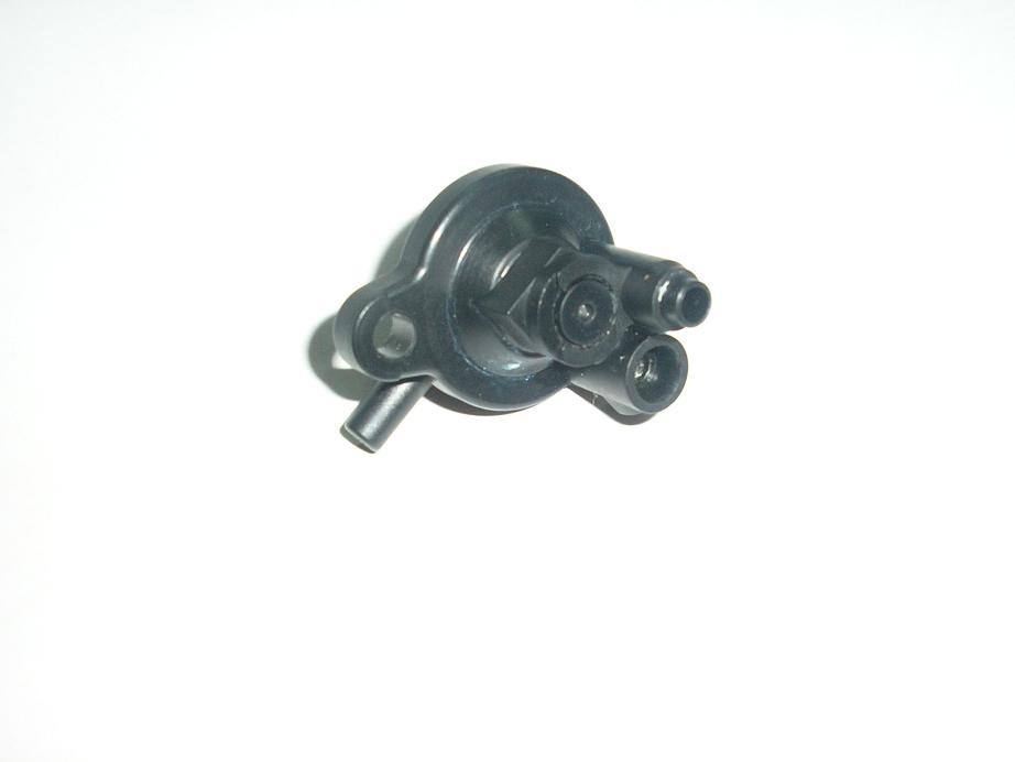 Small black plastic multi-port valve or fuel fitting on white background