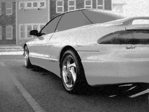 1996 Ford Probe - A white sports coupe is parked on a street with buildings in the background.