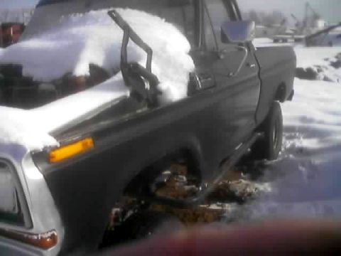 1979 Ford Bronco - A Ford pickup truck sits in the snow with its hood open, partially covered by snow.