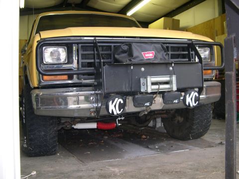 1982 Ford Bronco - Front view of a yellow Ford Bronco, likely from the early 1980s, equipped with a winch and KC lights.