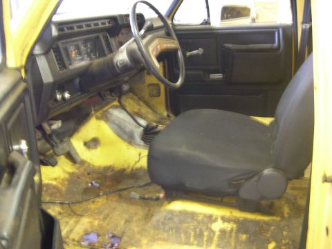 1982 Ford Bronco - Interior view of a yellow 1982 Ford Bronco, showing the dashboard, steering wheel, and driver's seat.